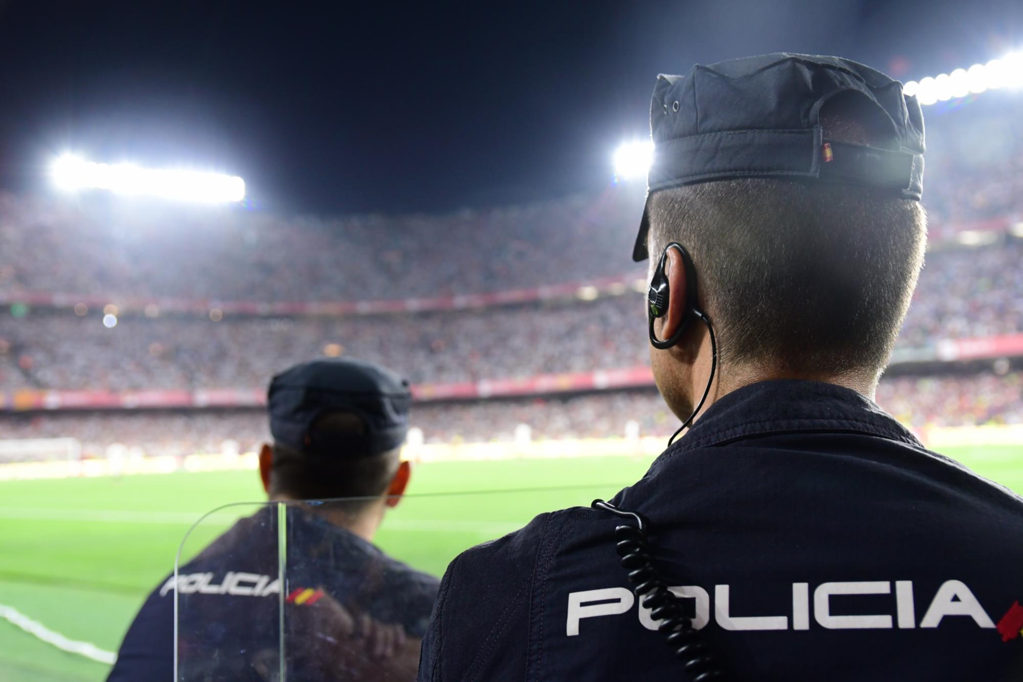 Policías nacionales vigilan a la afición en un campo de fútbol