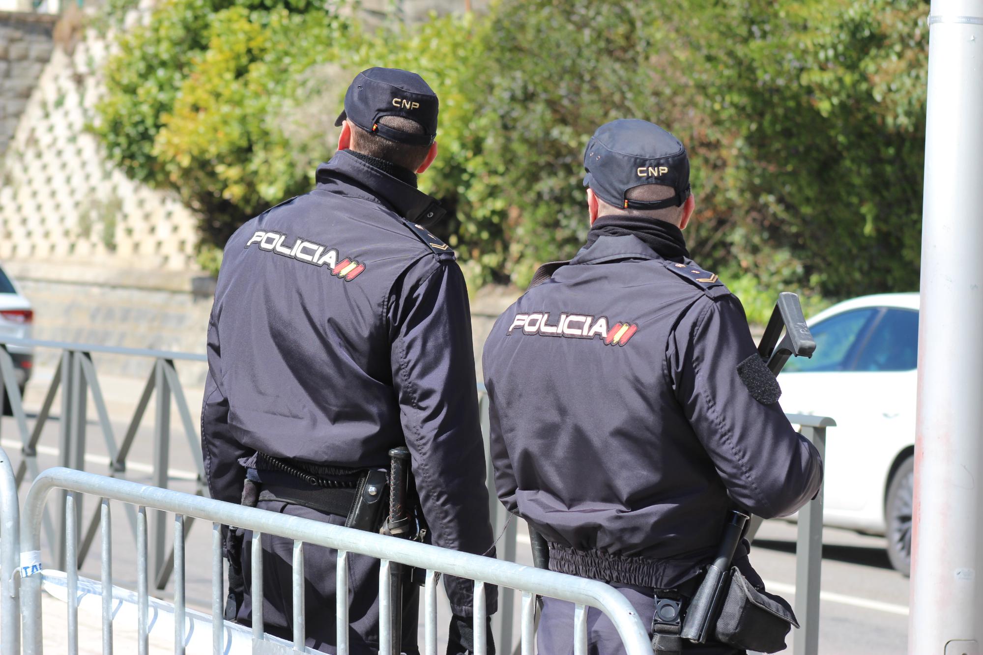 Imagen de dos agentes de la policía nacional de espaldas