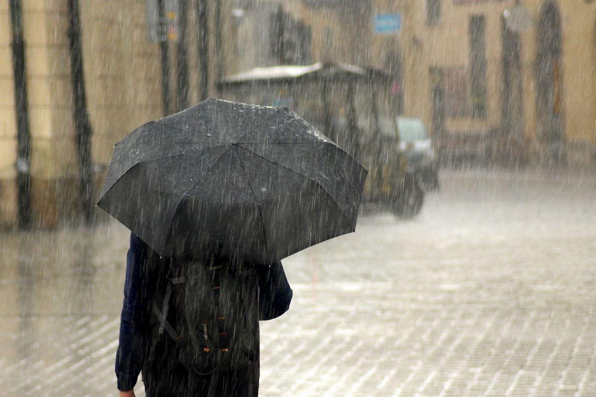 Imagen de un hombre que se protege de la lluvia con un paraguas