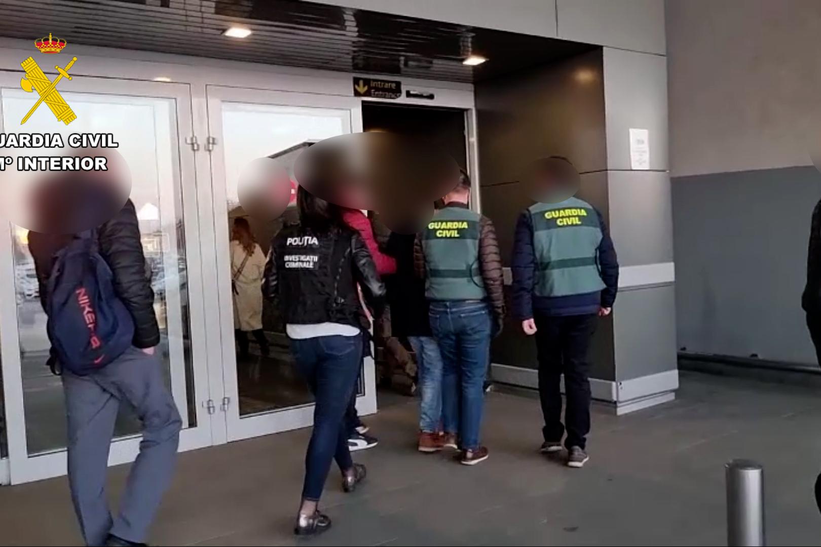 Guardia Civil y policía rumana con un detenido entran en unas dependencias