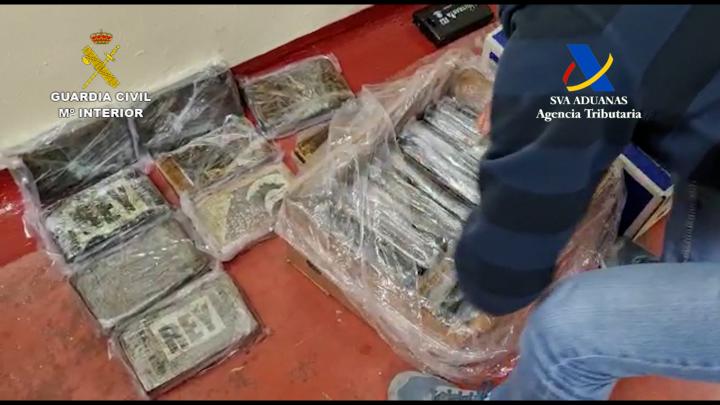 Agente de vigilancia aduanera con la cocaína incautada en el puerto de Valencia