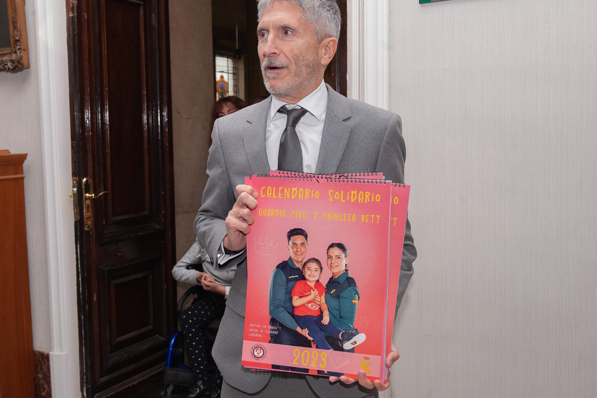 El Ministro Grande-Marlaska sostiene un calendario en  cuya portada aparecen guardias civiles