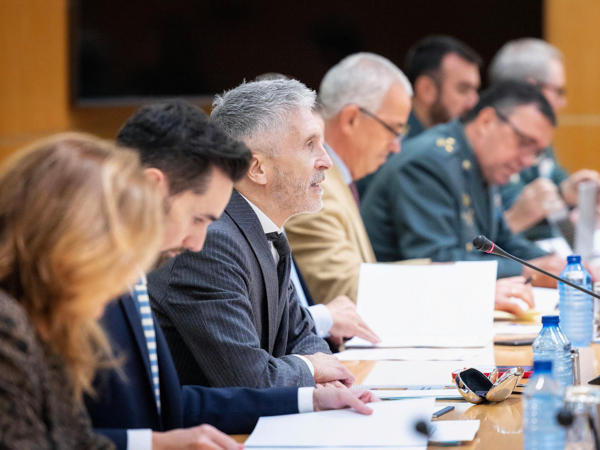 El Ministro del Interior, Fernando Grande-Marlaska, en un mesa¡, a su lado el secretario de estado y otras personas