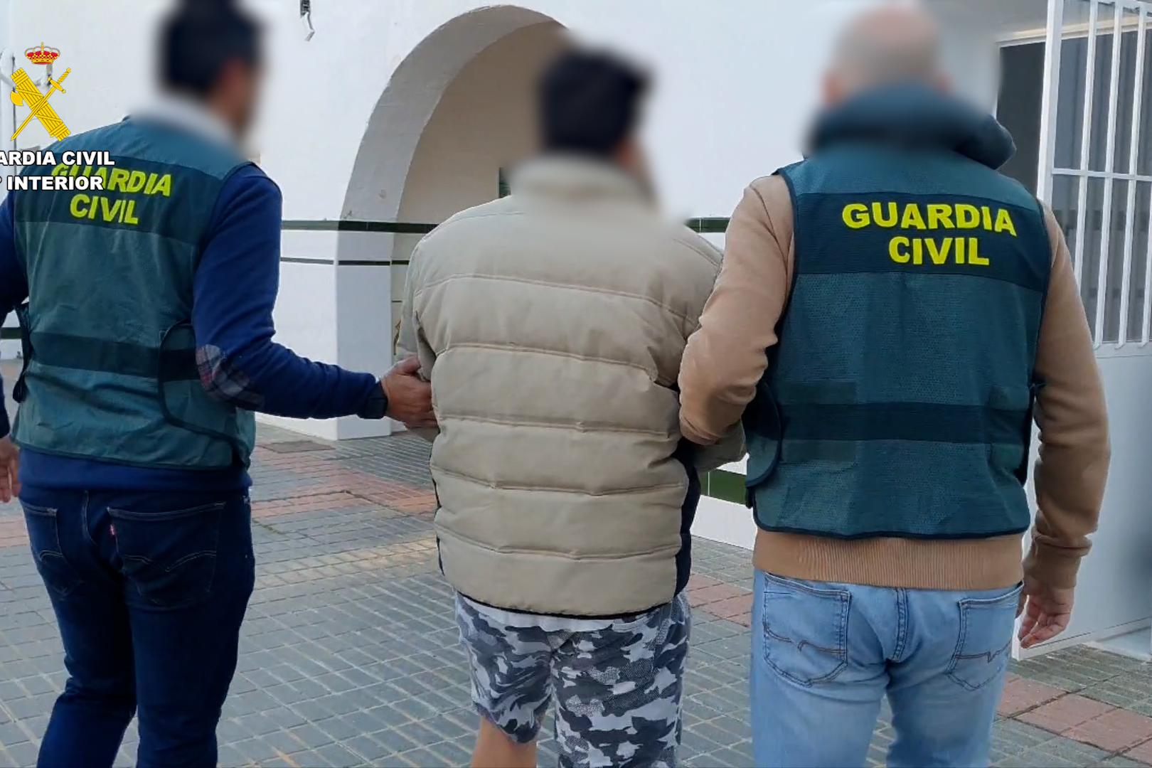Agentes de la Guardia Civil custodian y trasladan al detenido