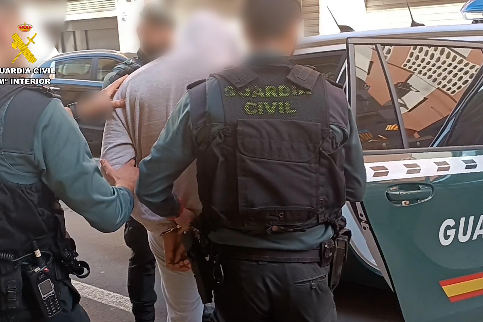 La guardia civil procede a introducir a uno de los detenidos en el coche