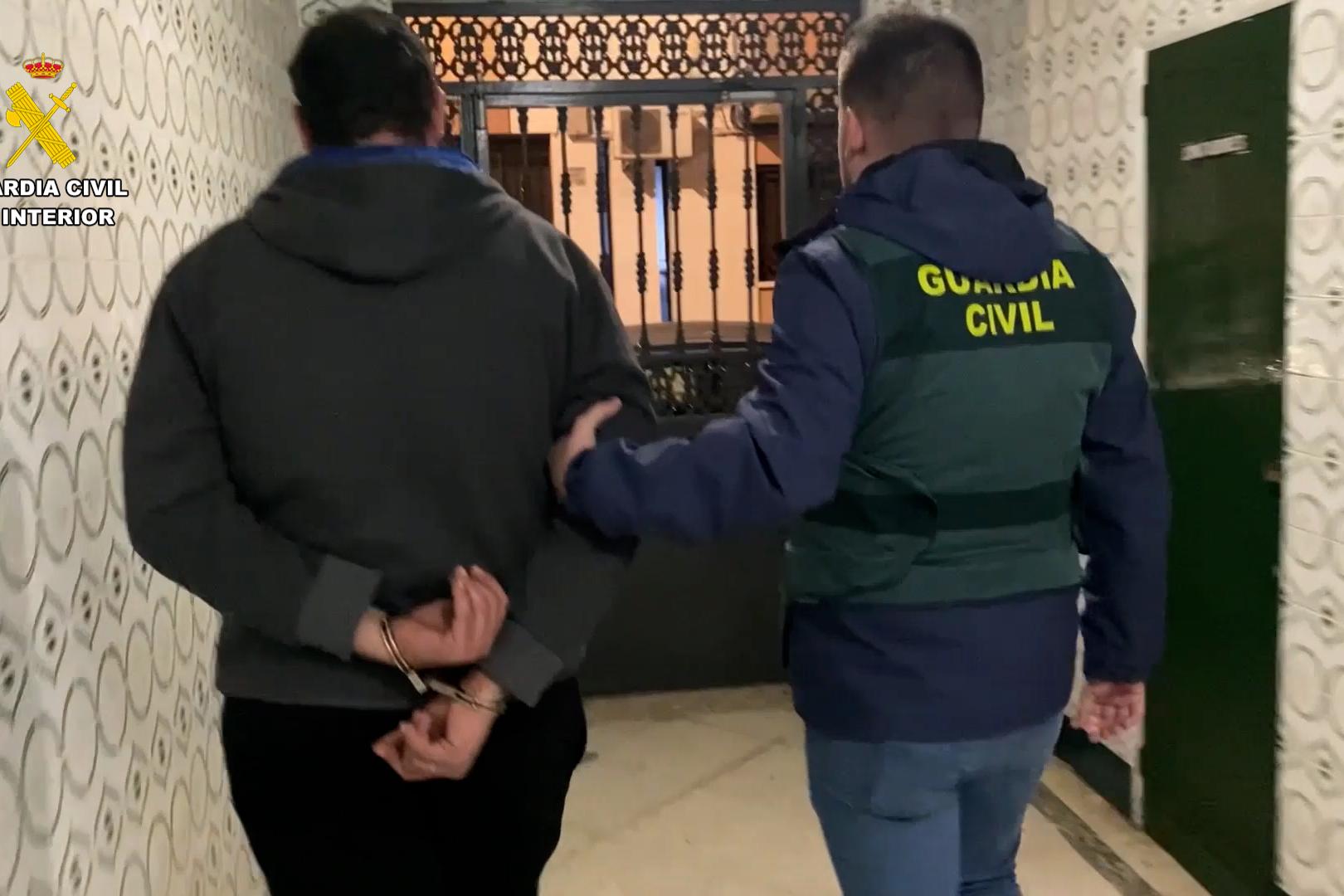 La guardia civil lleva del brazo al detenido que va esposado