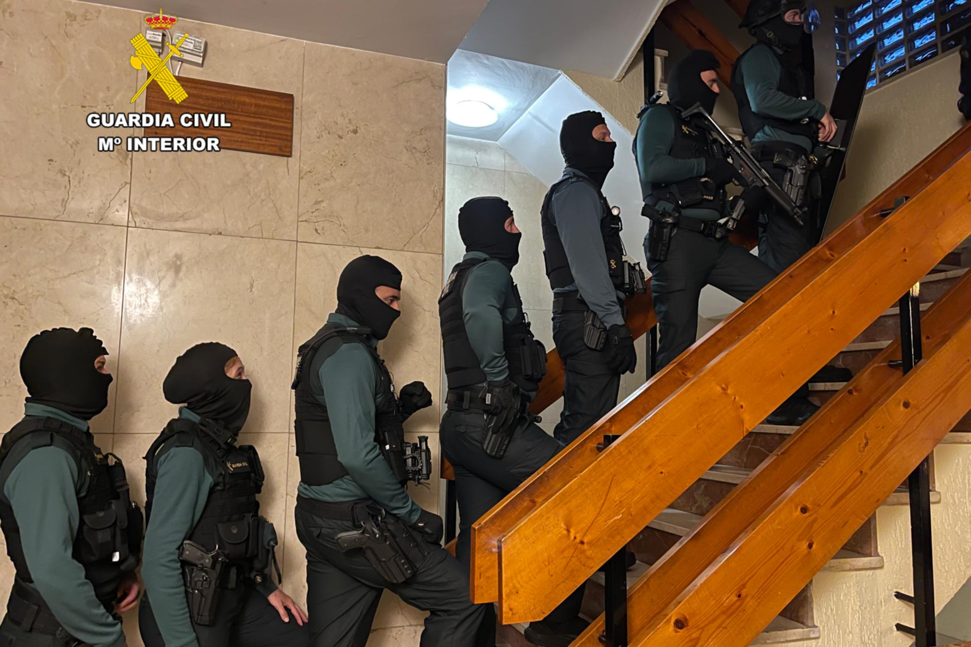 Agentes de la Guardia Civil momentos previos a entrar en uno de los domicilios