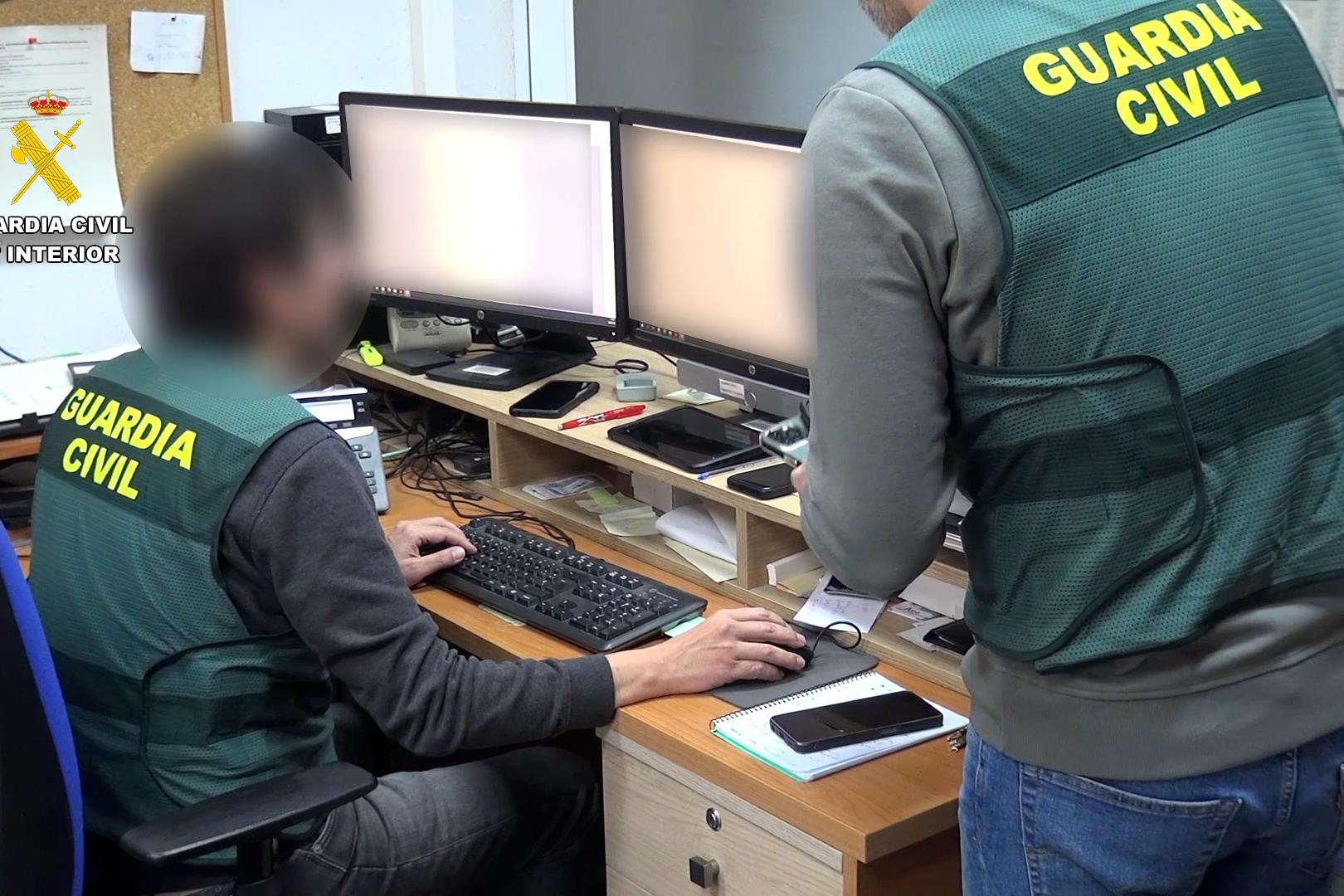 Agentes de la Guardia Civil registran las imágenes hayadas en los ordenadores de los detenidos