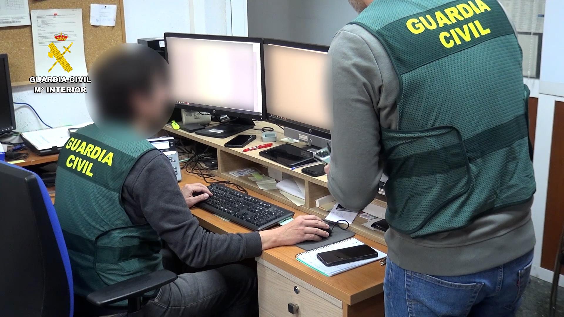 Agentes de la Guardia Civil registran las imágenes hayadas en los ordenadores de los detenidos