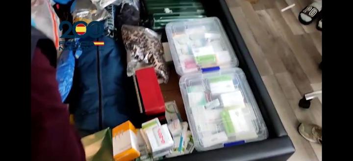 Agentes de la Policía Nacional hayan en el arcon de la cama gran cantidad de cajas de medicamentos durante el registro