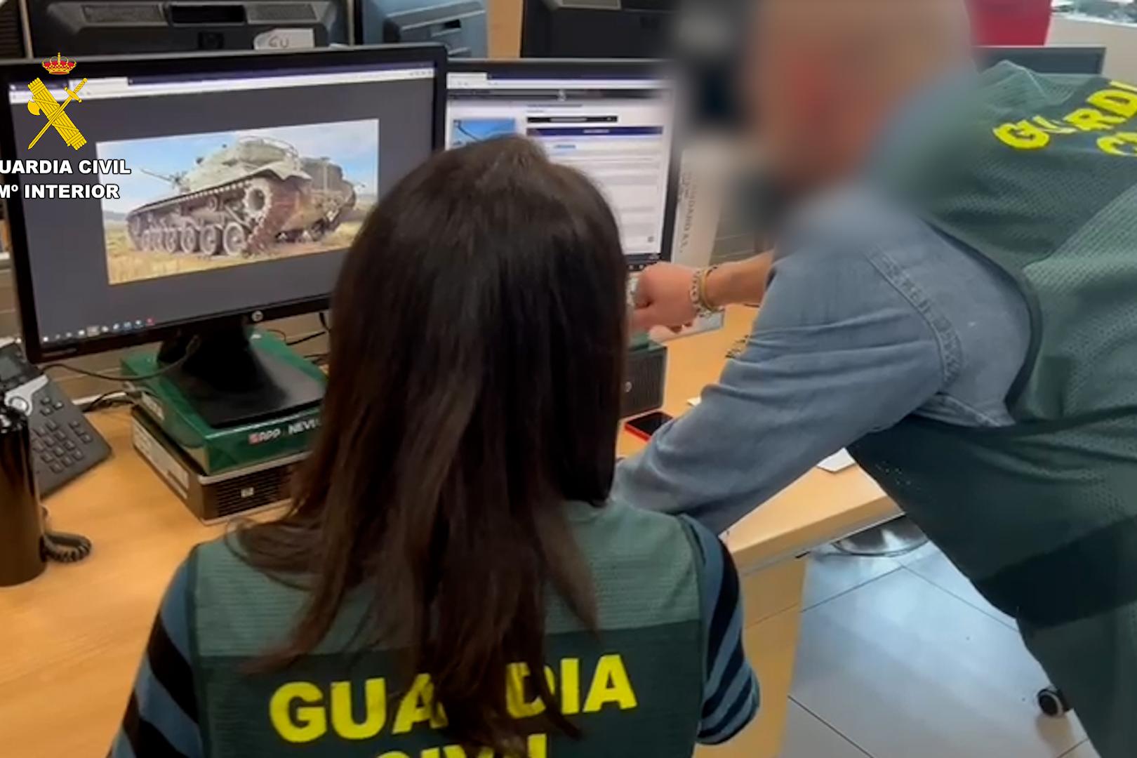 Dos agentes de la Guardia Civil visionan un carro de combate en un monitor