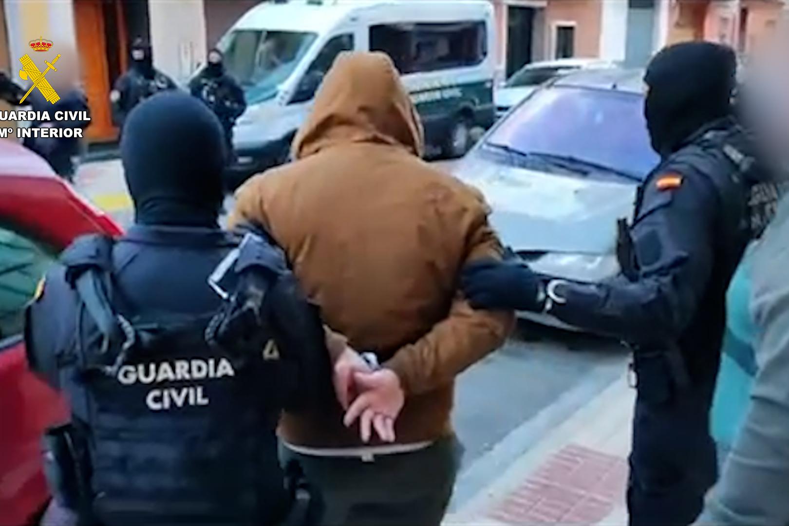 Agentes de la Guardia Civil trasladan a uno de los detenidos en la operación