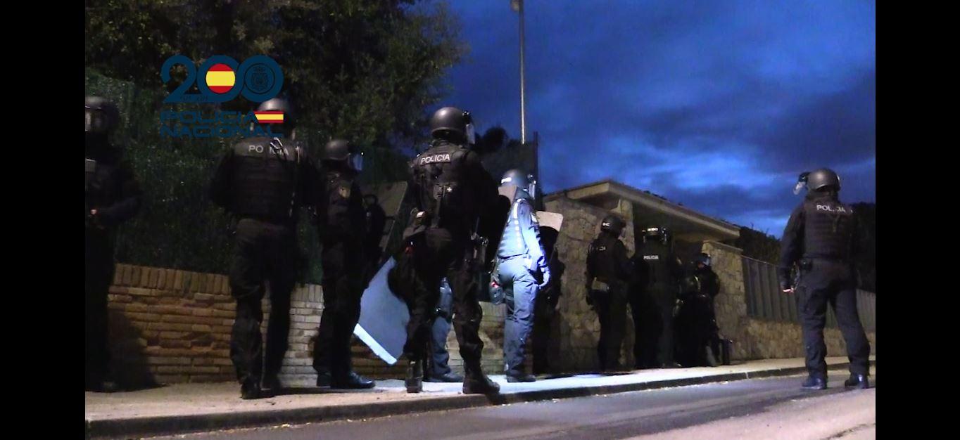 Agentes de la Policía Nacional se prepara para entrar en uno de ls domicilios investigados