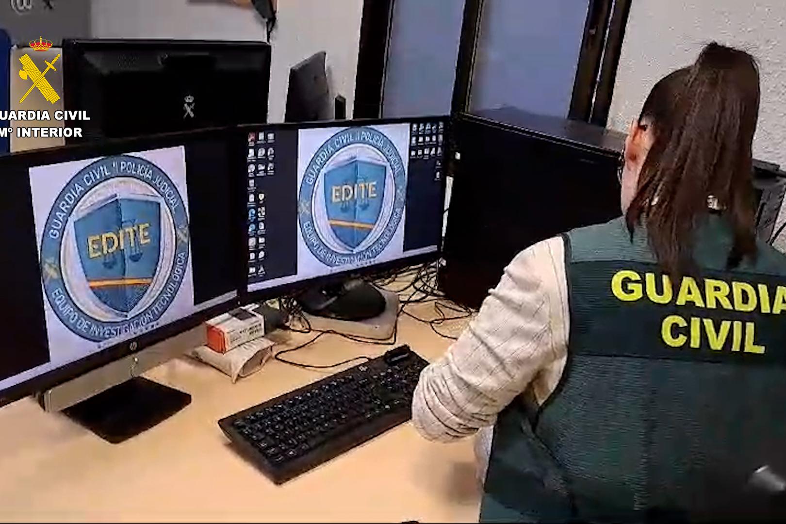 Una agente de la Guardia Civil inspecciona varios ordenadores