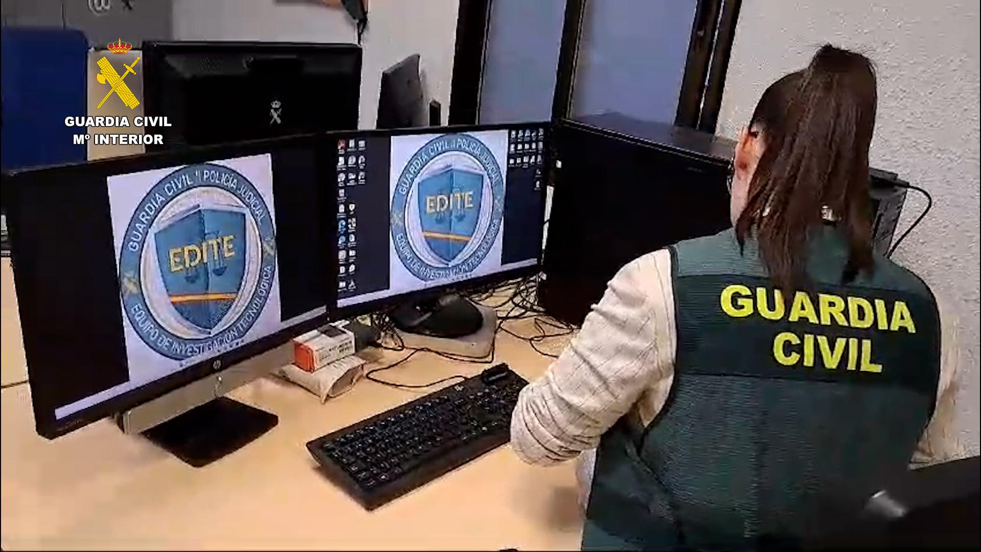 Una agente de la Guardia Civil inspecciona varios ordenadores