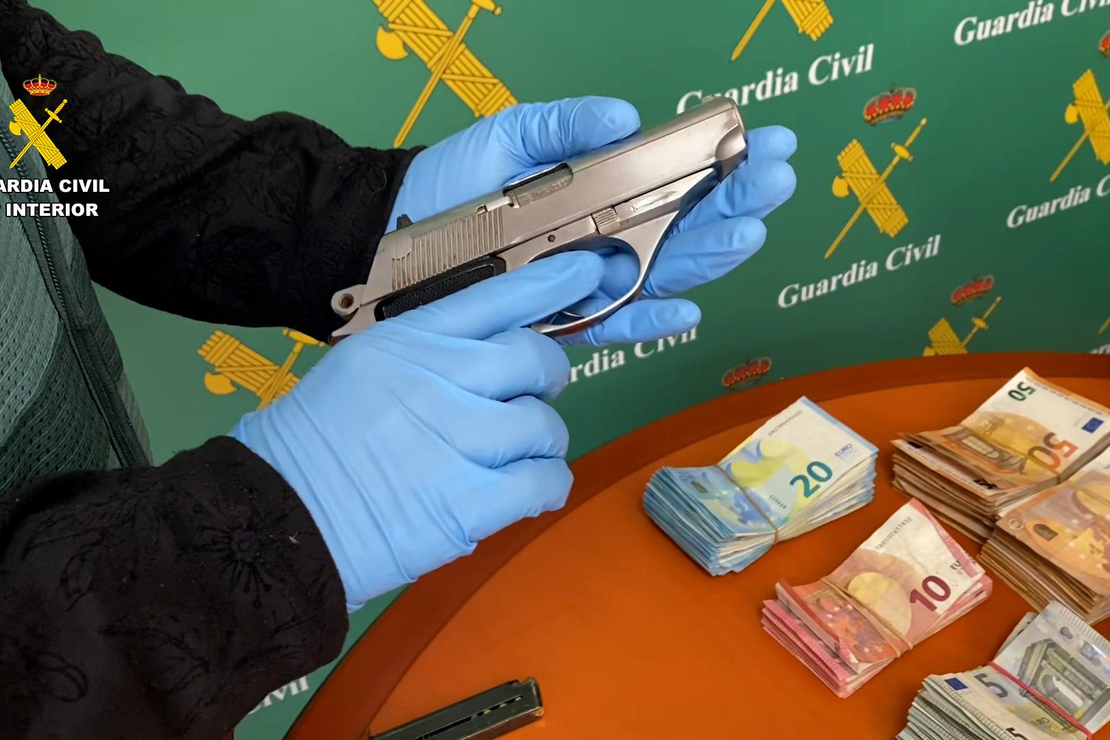 Imagen de una de las armas cortas y dinero incautados durante la operación