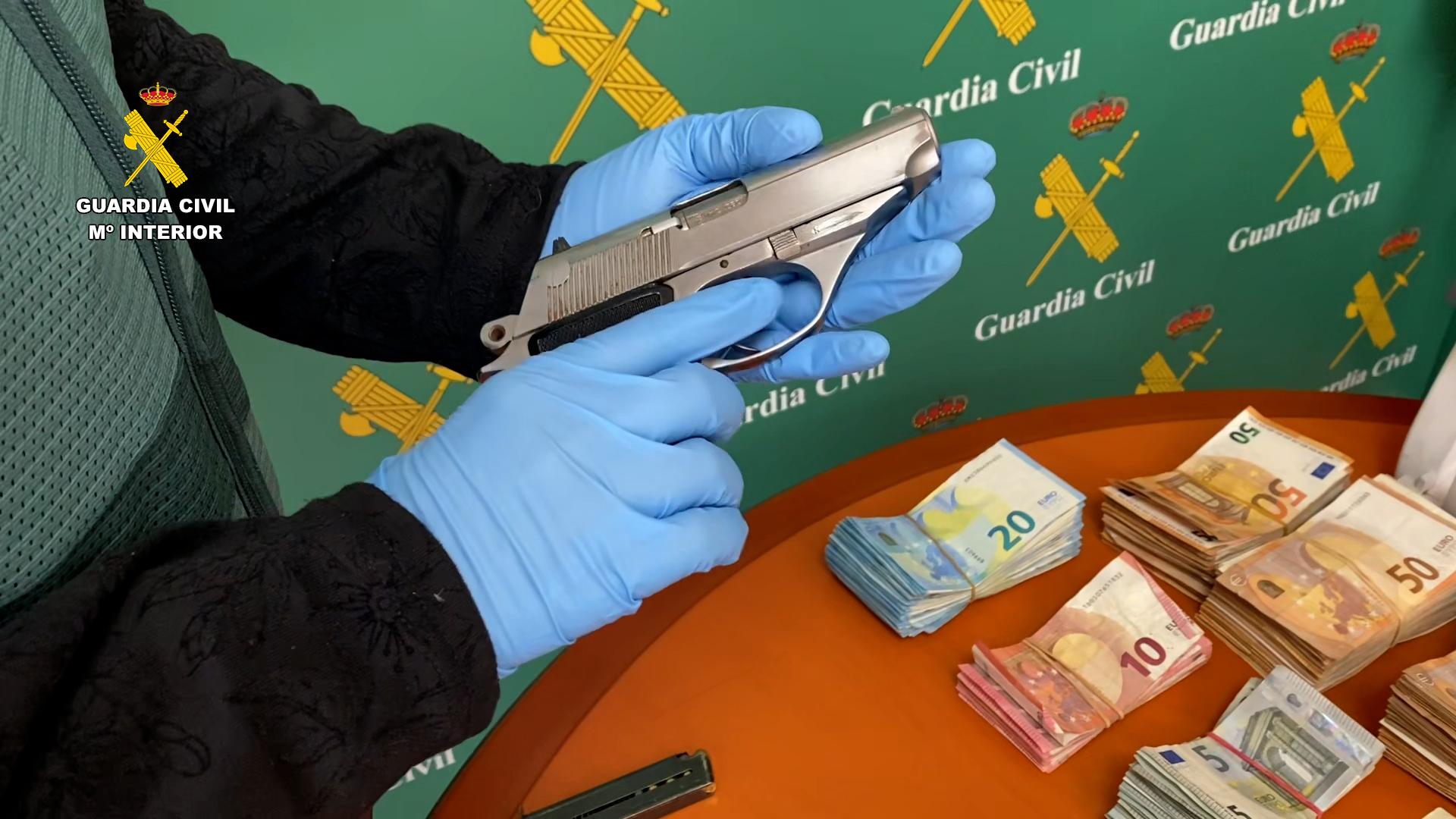 Imagen de una de las armas cortas y dinero incautados durante la operación
