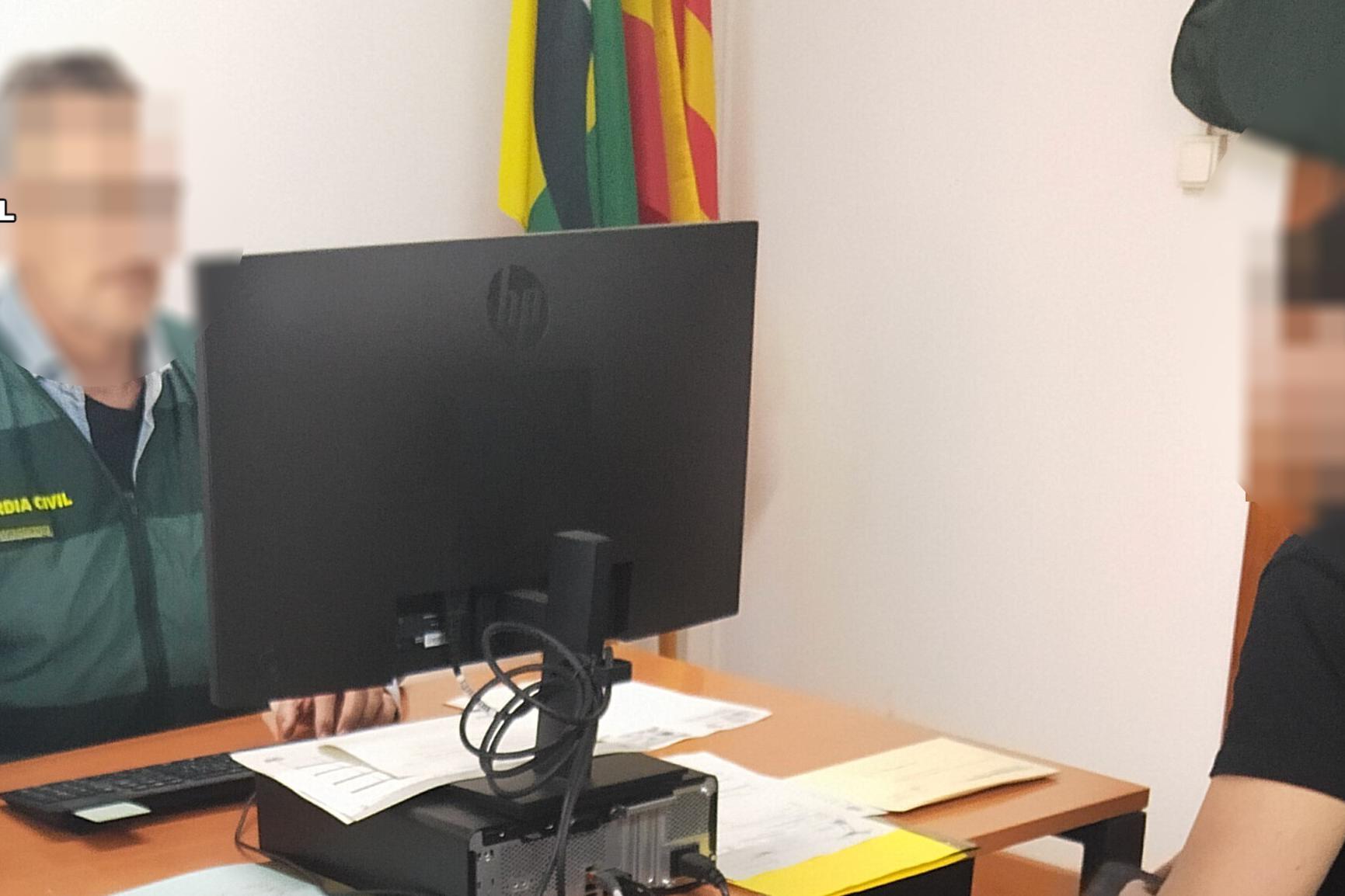 Agente de la Guardia Civil delante de un ordenador en una oficina